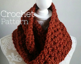 May include: A crocheted cowl in a rich rust orange colour. The cowl is made with a simple stitch pattern and is a great accessory for autumn and winter.