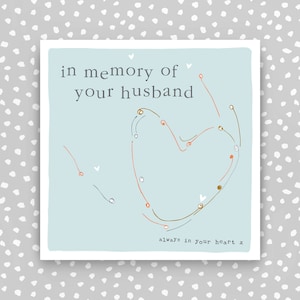 May include: A light blue card with a hand-drawn heart in orange, brown, and grey. The text "in memory of your husband" is at the top of the card. The text "always in your heart x" is at the bottom of the card.