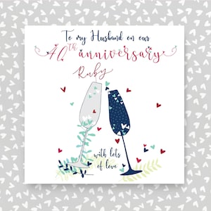 May include: A white card with a red and blue design. The card says "To my Husband on our 40th anniversary Ruby with lots of love".