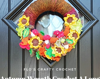 May include: A crocheted autumn wreath with sunflowers, leaves, and mushrooms. The wreath is made with brown yarn and is decorated with colorful crocheted flowers and leaves.
