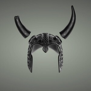 Puede incluir: Un casco vikingo negro con cuernos. El casco est&aacute; decorado con intrincados patrones.