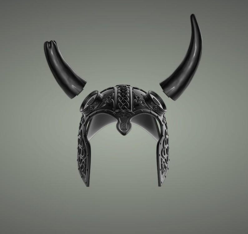Puede incluir: Un casco vikingo negro con cuernos. El casco est&aacute; decorado con intrincados patrones.