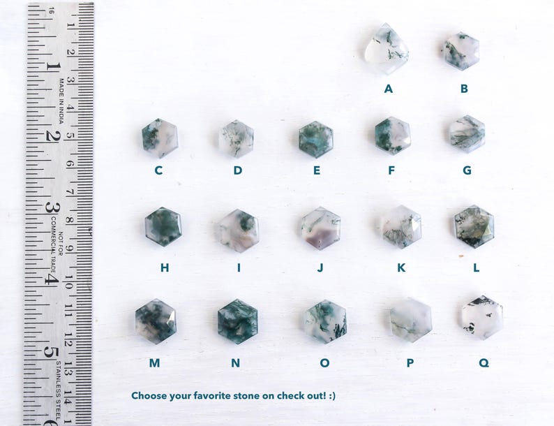 May include: A collection of seventeen moss agate stones in hexagonal and teardrop shapes, labeled A through Q, arranged in rows. A metal ruler on the left shows measurements in inches and centimeters. The text reads: Choose your favorite stone on check out! :)