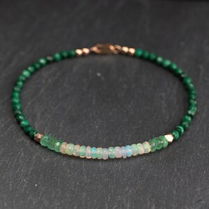 Puede incluir: Una pulsera de cuentas con una hilera de peque&ntilde;as cuentas de malaquita verde oscuro facetadas, acentuada con una fila central de rondeles de &oacute;palo blanco iridiscente y peque&ntilde;as cuentas espaciadoras met&aacute;licas en tono oro rosa, con un cierre met&aacute;lico a juego.