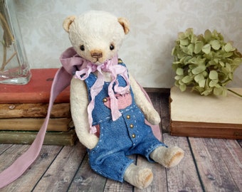 Teddy bear in denim overalls and a hat with rabbit ears   Cute gift for a girl