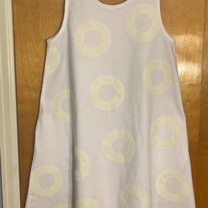 May include: A white sleeveless dress with a circle pattern. The circles are a light cream color and are scattered across the dress.