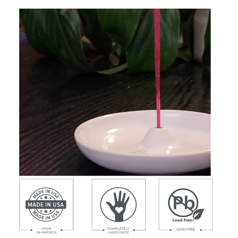May include: White ceramic incense holder with a small, raised center for holding incense sticks. A red incense stick is burning in the holder. The holder is made in the USA and is lead-free.