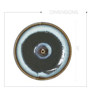 May include: A round, black and blue ceramic incense burner with a small hole in the center. The burner has a white rim and measures 3.5 inches in diameter.