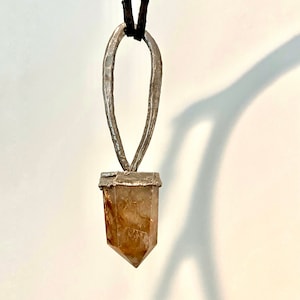 Faceted quartz crystal pendant with various inclusions