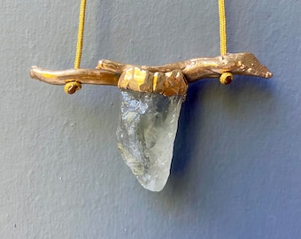 Raw quartz with a twig pendant