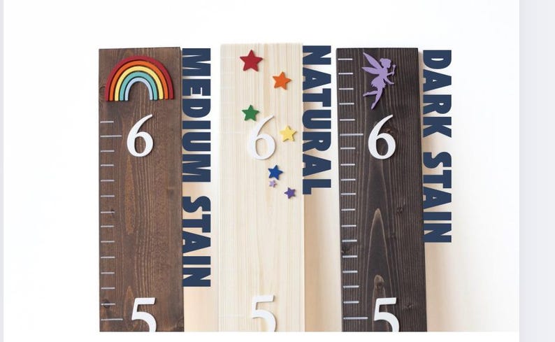 May include: Four wooden growth charts with different stain colors: natural, medium stain, dark stain. Each chart features a number 6 and a design: a rainbow, stars, and a fairy.