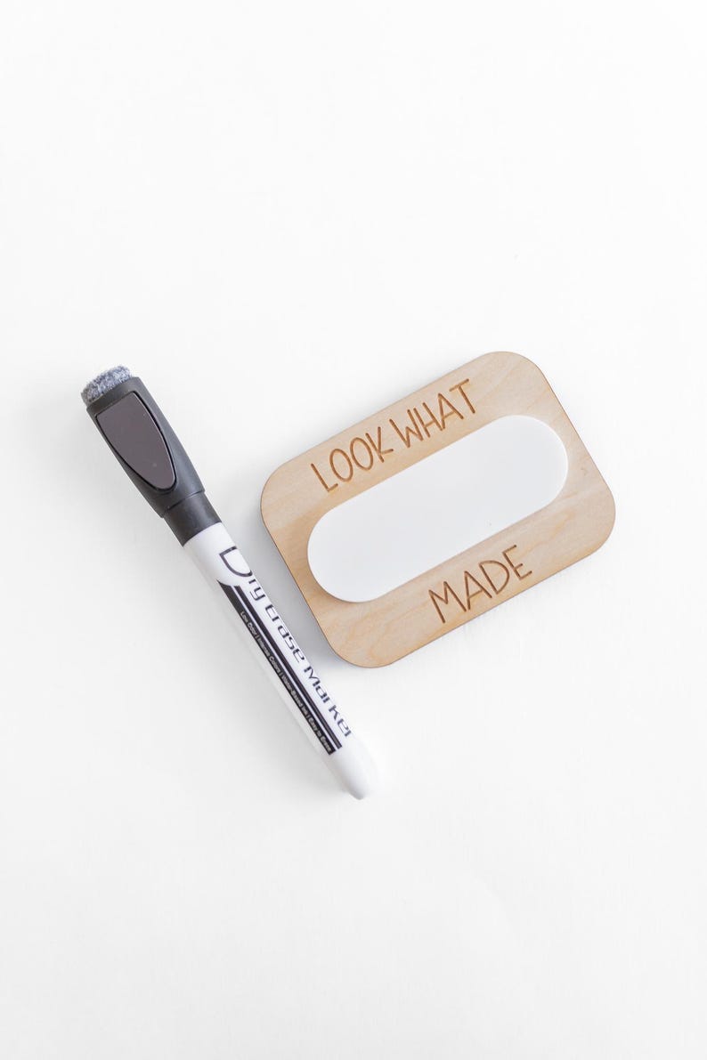 May include: A wooden sign with the text "LOOK WHAT I MADE" and a blank oval space in the center. A dry erase marker is next to the sign.