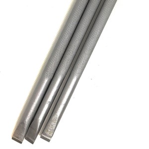 Puede incluir: Tres herramientas de trabajo de cuero de metal plateado con mangos texturados.