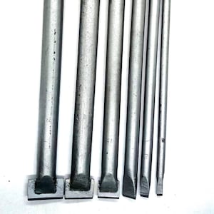 Puede incluir: Seis herramientas de metal plateado con puntas de diferentes formas. Las herramientas tienen todas la misma longitud y una superficie ligeramente texturizada.
