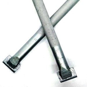 Puede incluir: Dos herramientas de metal plateado con cabezales cuadrados y mangos texturados. Las herramientas están marcadas con el número "32".