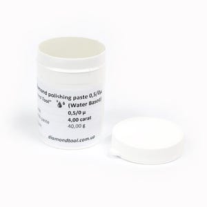以下が含まれることがあります： 蓋が外されたダイヤモンド研磨ペーストの白い円筒形の容器。容器には「diamond polishing paste 0,5/0 μ (Water Based) 4,00 carat 40,00 g」と書かれています。