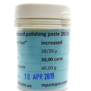 May include: A blue and white label on a white jar of diamond polishing paste. The label reads "Diamond polishing paste 28/20 increased 28/20 μ 30,000 carat 40,000 g 10 APR 2019" and includes the website addresses "tool.com.ua" and "mpxyupin.com".