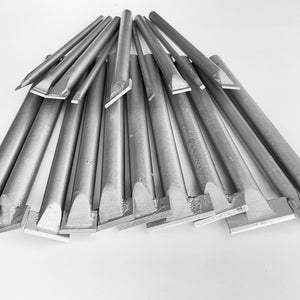 Puede incluir: Un conjunto de cinceles de acero, de diferentes tamaños y formas, dispuestos sobre una superficie blanca. Los cinceles tienen bordes de corte planos y biselados y mangos largos y cilíndricos. Estas herramientas se utilizan probablemente para carpintería o cantería.