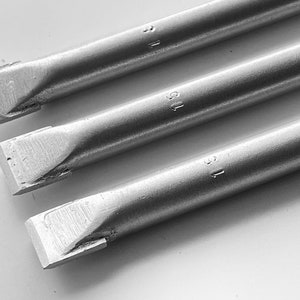 May include: Three silver metal rods with a square tip. Each rod has the number "1" engraved on the side.