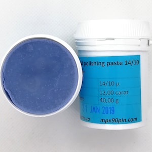 May include: A container of blue polishing paste with the lid off, revealing the product. The container next to it has a label with text including "polishing paste 14/10", "12,00 carat", and "40,00 g". The date "21 JAN 2019" is also visible.