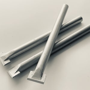 Puede incluir: Tres herramientas de metal plateado con puntas cuadradas. Las herramientas están sobre una superficie blanca. La herramienta del centro tiene el número "9.2" grabado.