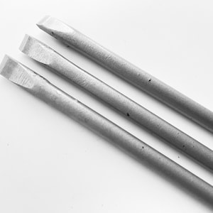 Puede incluir: Tres destornilladores de metal plateado con cabezales planos.