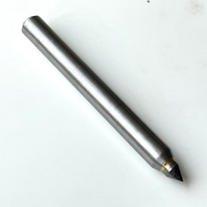 May include: A silver metal tool with a pointed tip, used for carving or shaping wood.