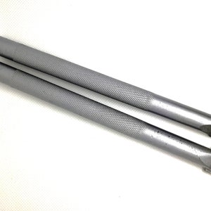 Op de afbeelding: Twee zilveren metalen gereedschappen met een getextureerd oppervlak en een puntige punt. De gereedschappen worden gebruikt voor het snijden of beeldhouwen.