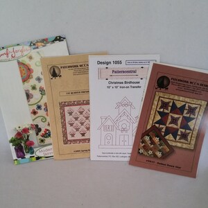 May include: Four quilting pattern designs, including a red, white, and blue star pattern, a spring floral pattern, a birdhouse pattern, and a Christmas birdhouse pattern. The patterns are printed on white paper with black ink. The text on the patterns includes the names of the patterns, the designers, and the sizes of the patterns.