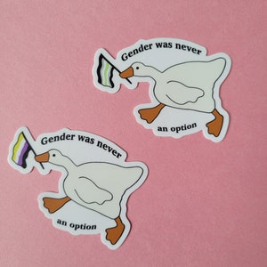 May include: Two white goose stickers with a genderqueer flag. The goose on the left is holding the flag in its beak and running. The text on the sticker reads "Gender was never an option".