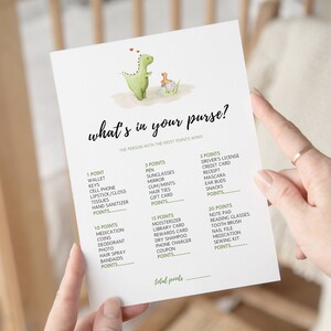 Può includere: Una carta di gioco stampabile con un'illustrazione di un dinosauro verde. La carta contiene un elenco di oggetti da trovare in una borsa con punti assegnati a ciascun oggetto. Il testo sulla carta dice "What's in your purse? The person with the most points wins!"