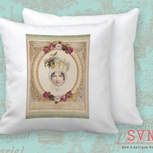 May include: A white pillow with a vintage illustration of a woman wearing a large, ornate hat with flowers. The illustration is framed with a gold and white border and has a light green background. The text "Le Portrait" is printed below the image.
