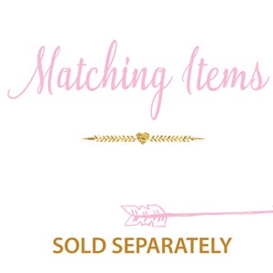 May include: Pink text on a white background reads "Matching Items". A gold glitter arrow with a heart in the middle points to the right. Below the arrow, gold text reads "SOLD SEPARATELY".