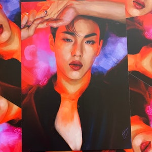 May include: A portrait of a person with dark hair and a black shirt. The person is looking at the camera with a serious expression. The background is a vibrant mix of pink, orange, and blue.