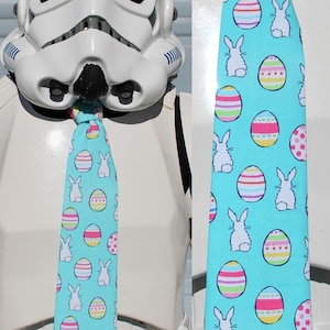 May include: A blue tie with a pattern of white bunnies and colorful Easter eggs.