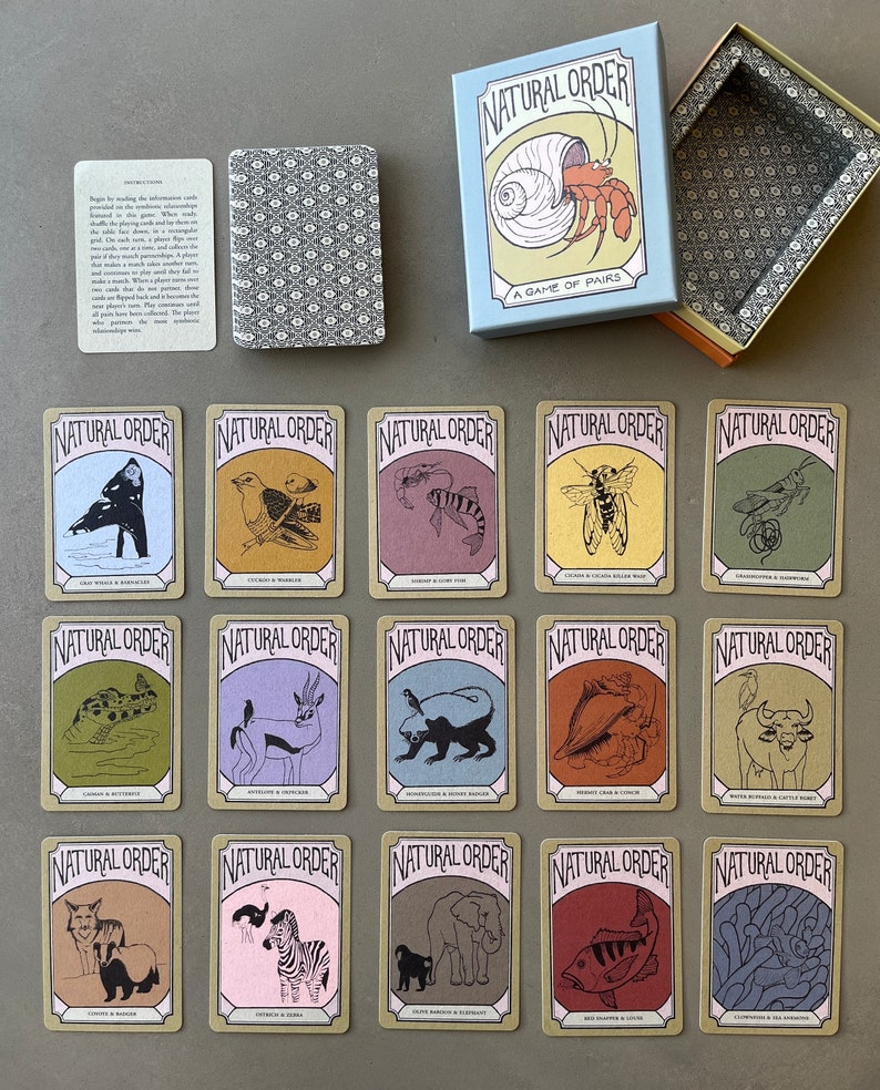 May include: A set of 15 cards for a game called "Natural Order." Each card features a different animal illustration with a brown border and white text. The text on each card includes the name of the animal and its predator. The cards are arranged in three rows of five cards each.