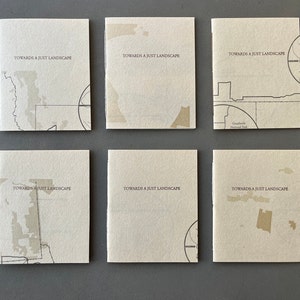 May include: Six small, off-white, square books with the text "Towards a Just Landscape" printed on the front cover. Each book features a different black and white map design.