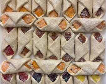 May include: A collection of 36 small, white, glittery ornaments shaped like a pastry. The ornaments have different colored fillings, including red, orange, yellow, purple, and blue.