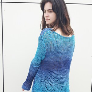 May include: A blue and purple ombre knit sweater with a loose fit and long sleeves.