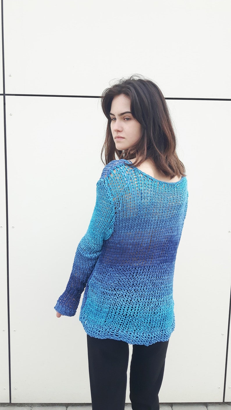 May include: A blue and purple ombre knit sweater with a loose fit and long sleeves.