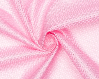 Op de afbeelding: Roze stof met een textuur, geweven patroon. De stof is gevouwen en gedraaid, waardoor een wervelend effect ontstaat.