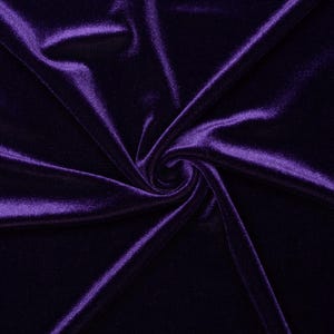 May include: Close-up of a deep purple velvet fabric. The fabric is draped and swirled, creating shadows and highlights that emphasize its soft texture. The rich color and sheen suggest a luxurious material suitable for apparel or home decor.