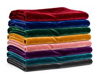 May include: A stack of eight folded velvet fabric pieces in various colors, including deep red, royal blue, emerald green, mustard yellow, light pink, dark purple, teal, and charcoal gray, arranged in a neat, horizontal pile.