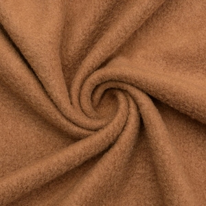 May include: Close-up of a brown fabric with a soft, fuzzy texture. The fabric is folded and draped, showing its natural drape and texture.