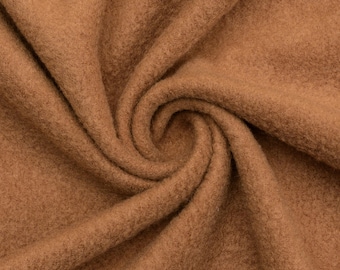 May include: Close-up of a brown fabric with a soft, fuzzy texture. The fabric is folded and draped, showing its natural drape and texture.