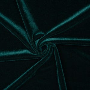 May include: A close-up of a deep green velvet fabric, showing the soft texture and rich color.