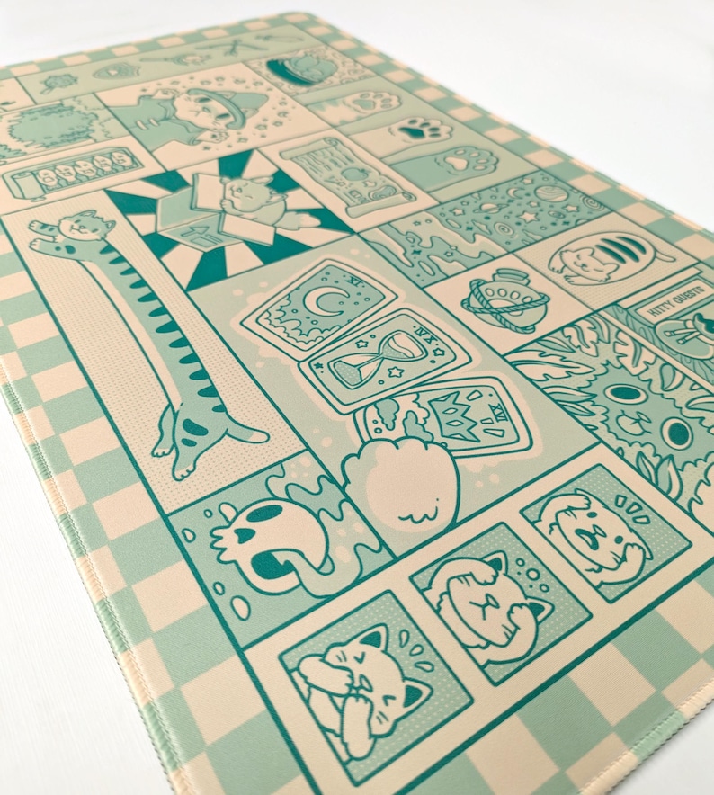 May include: A rectangular, light blue and beige mat with a comic strip design featuring cats. The design includes various cat illustrations, tarot cards, and other whimsical elements. The mat has a checkered border.