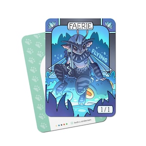 May include: A fantasy art card featuring a blue and grey faerie with the text "FAERIE" and "FLYING". The faerie is sitting on a blue creature. The card is paired with a second card with paw prints.