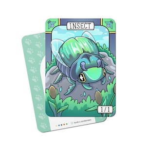 May include: A green and blue insect card with a cartoon beetle on a rock surrounded by green plants. The card has the word "INSECT" at the top and "1/1" at the bottom.
