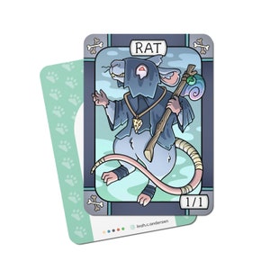 May include: A playing card featuring a cartoon rat wearing a black hooded robe and holding a staff. The card is titled "RAT" and has a 1/1 power rating. The card is designed in a stained glass style with a blue and green color scheme.